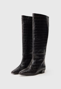 Czarne skórzane buty do kolan z teksturą krokodylej skóry, z wydłużonym noskiem i niskim obcasem. Charakteryzują się eleganckim fasonem i detalami w postaci przeszyć.