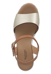 Hnedé a metalicky zlaté kožené sandále so širokým popruhom, prackou na členku a tvarovanou stielkou. Obsahujú pletenú espadrilovú pätu.
