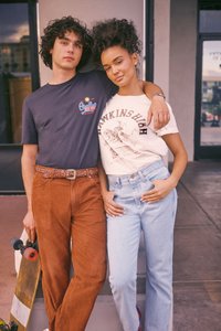 Kaks inimest poseerivad koos. Ühel on seljas tume t-särk ja pruunid sametp�üksid, teisel kreemikas t-särk mustade graafiliste elementidega ja helesinised teksad.