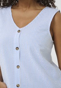 Abito senza maniche a righe blu e bianche con scollatura a V, caratterizzato da quattro bottoni rotondi marroni davanti e un tessuto morbido e texturizzato.