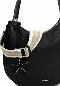 Sac à main noir texturé avec une bandoulière en tissu rayé beige, blanc et gris, et un pendentif en forme d'étoile noire orné de clous argentés.