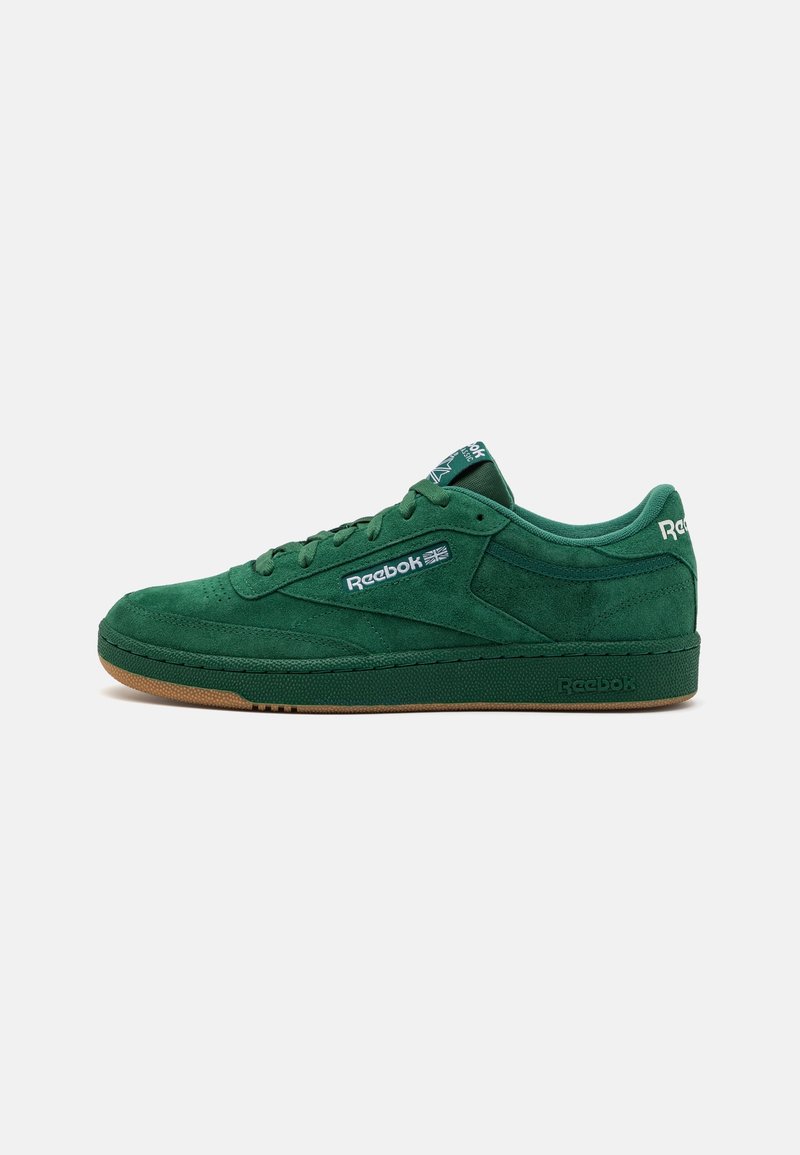 Baskets basses vertes en daim Reebok avec un design à lacets et une semelle en gomme, affichant le logo Reebok sur le côté, la languette et le talon.