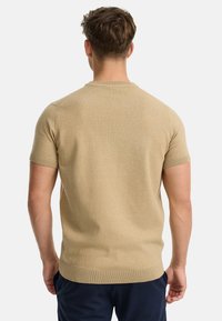 Suéter beige de manga corta, textura de punto, cuello redondo, puños y dobladillo acanalados, tejido suave, silueta ajustada, diseño liso.