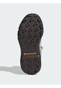 Potplat cipela s robusnim, teksturiranim crnim gumama. Ima istaknute utore za prianjanje i "Continental" brendiranje u narančastoj boji.