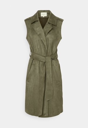 Bezrekawnikowy płaszcz trencz w oliwkowej zieleni z paskiem, kołnierzem z klapami, dwoma bocznymi kieszeniami i pagonami na ramionach.