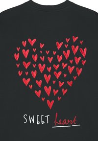 Felpa nera con un grande cuore rosso composto da cuori più piccoli, con il testo "SWEET" in bianco e "heart" in rosso in corsivo sotto.