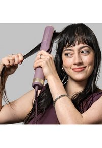 Hårutretter i lilla med gullige detaljer, rund form, teksturert grep, og tilkoblet kabel. Håret blir stylet i strenger.