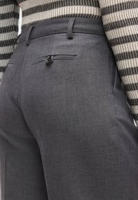Γκρι παντελόνι προσαρμοσμένης ραφής με ομαλή υφή υφάσματος, που διαθέτει πίσω τσέπη με μαύρο κουμπί και εφαρμοστό ζωνάρι στη μέση.