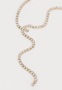 Χρυσή αλυσίδα με κολιέ που διαθέτει καθαρές, στρογγυλές ραβδώσεις διαμαντιών τοποθετημένων σε μία μόνο σειρά πάνω σε ανοιχτό φόντο.