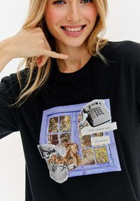 Czarna koszulka z grafiką niebieskiego okna, vintage'owego telefonu, zmiętego papieru oraz szkiców gwiazd, zastosowanych w różnych teksturach.