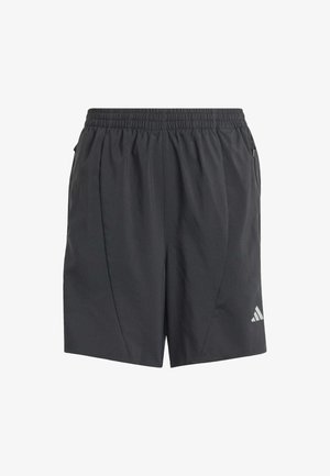 Top atlético negro sin mangas con logotipo blanco, combinado con pantalones cortos negros. Usado con zapatillas deportivas blancas con detalles en negro.