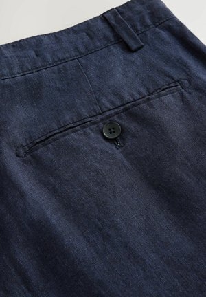 Pantalones de lino azul marino con una textura suave, cierre de un solo botón y un bolsillo trasero con un detalle de costura sutil.