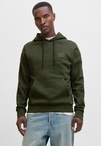 Olive green hoodie with front pocket, drawstring hood, and small logo on chest. Soft material, relaxed fit, paired with light blue jeans.