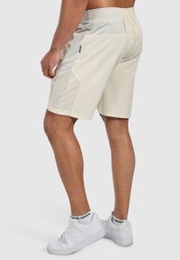 Ljusbeiga träningsshorts med en texturerad grå midjeband och mesh-sidofickor, med en vanlig passform och längd ovanför knäna.