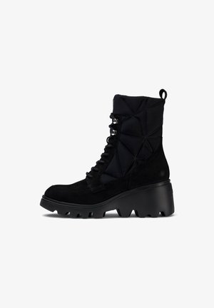 Botas negras hasta el tobillo con una combinación de ante liso y tela texturizada. Suela gruesa tipo trek, parte frontal con cordones y un patrón geométrico distintivo en el empeine.