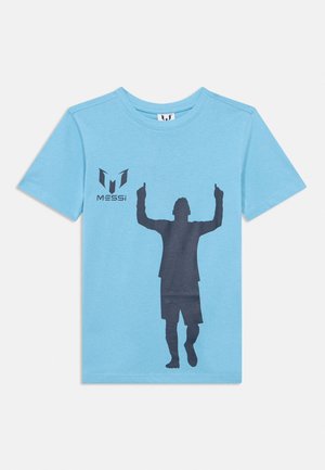 Vaaleansininen T-paita, jossa on musta jalkapalloilijan siluetti nostamassa molempia käsiään, ja ”MESSI”-logo vasemman rinnan kohdalla.