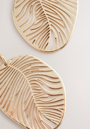 Ohrringe in Form von goldenen Blättern mit ausgeschnittenen Mustern der Blattadern. Glatte Oberfläche mit poliertem Finish. Großes, leichtes Design.