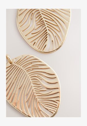 Ohrringe in Form von goldenen Blättern mit ausgeschnittenen Mustern der Blattadern. Glatte Oberfläche mit poliertem Finish. Großes, leichtes Design.