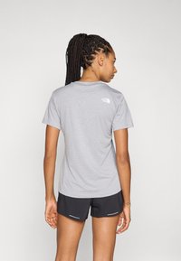 Grijs T-shirt met korte mouwen en ronde hals, met logo-detail op de achterkant, gecombineerd met zwarte shorts met lichtblauwe accenten.