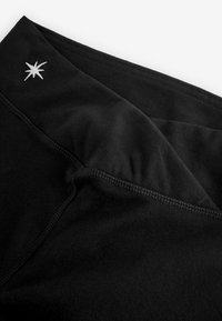 Fekete anyag puha tapintással, szélén fehér csillag hímzéssel. A varrások mentén a cérnázás gondosan befejezett.