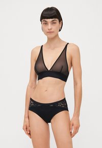 Black lingerie set featuring a sheer mesh bralette with V-neck and matching brief with lace accents at the waistband. Soft elastic materials.