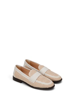 Para beżowych mokasynów z białą skórzaną lamówką i ciemnobrązowymi podeszwami, ustawionych obok siebie na białym tle.