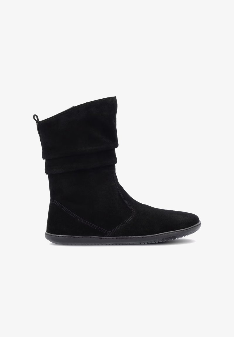 Schwarzer knöchelhoher, lässiger Stiefel mit flacher Sohle und rundem Zeh, mit Zuglasche an der Rückseite, seitlich auf weißem Hintergrund gezeigt.