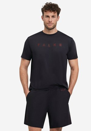 Camiseta atlética negra y pantalones cortos con un sutil logo en rojo oscuro. Tejido suave con corte regular y bolsillos laterales en los pantalones cortos.