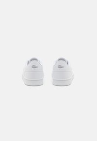 Hvite lær sneakers med en jevn tekstur og polstret krage, med en subtil sølv logo på baksiden og en hvit gummisåle.