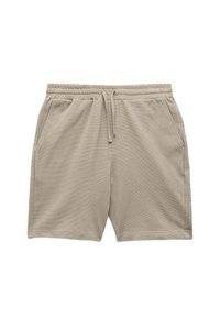 Shorts beige realizzati in un tessuto testurizzato. Presentano una vita elasticizzata con cordoncino e due tasche laterali.