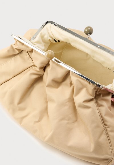 Μπεζ υφασμάτινη τσάντα χειρός με σχεδιασμό ραβδώσεων, ασημί μεταλλικό κλείσιμο και εσωτερικό σε κρεμ απόχρωση. Διαθέτει δύο στρογγυλά κουμπιά κλεισίματος στην κορυφή.