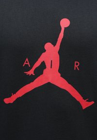 Κόκκινο γραφικό ενός πηδηχτού φιγούρας με μπάσκετ σε μαύρο φόντο, με τα γράμματα "Α", "Ι" και "Ρ" δίπλα από τη σιλουέτα.