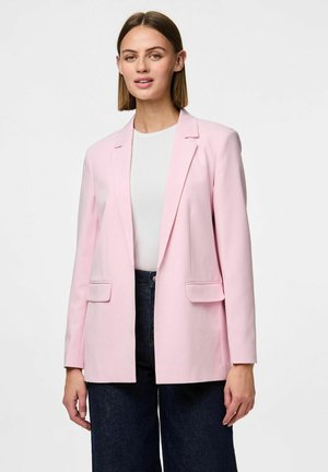 Lichtroze blazer met een ontwerp met één knoop, gekartelde revers en twee voorzakken. Draagt over een wit top, gecombineerd met donkere jeans.