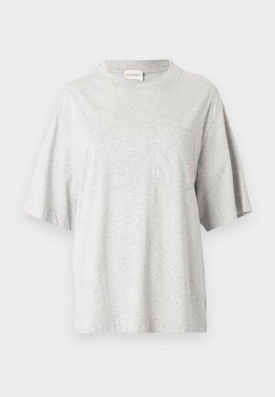 Γκρι βαμβακερό μπλουζάκι με στρογγυλή λαιμόκοψη, κοντά μανίκια και τσέπη στο αριστερό στήθος. Διαθέτει μια μικρή ετικέτα στη ραφή της πλαϊνής πλευράς.