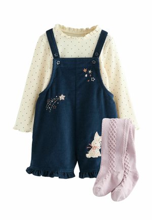 Denim schort met zijzakken, donkerblauwe kleur en decoratieve borduursels van sterren; crèmekleurige blouse met lange mouwen en stippen; roze gebreide panty's.