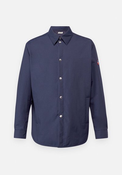 Marineblå skjorte med knapper, krave, lange ærmer, sølvknapper og en lapel på venstre arm. Glat stof med en afslappet pasform.