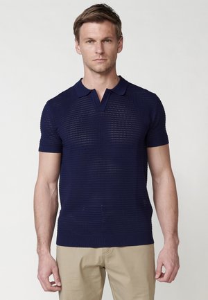 Polo shirt navy blu con maniche corte, caratterizzato da un motivo in maglia testurizzata, con colletto e orlo a costine, progettato per una vestibilità attillata.