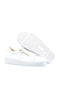 Valkoiset tennarit, joissa on teksturoitu nahkapinta, sivuvetoketju, paksu valkoinen kumipohja ja vaakaraitoja pohjassa.