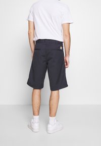 Marintröja shorts i slitstarkt material, med avslappnad passform, bakfickor och en diskret logotyp på midjebandet.