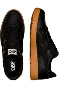 Black leather sneakers with a textured finish, lace-up design, and a gum rubber sole. Features an Asics logo on the tongue.