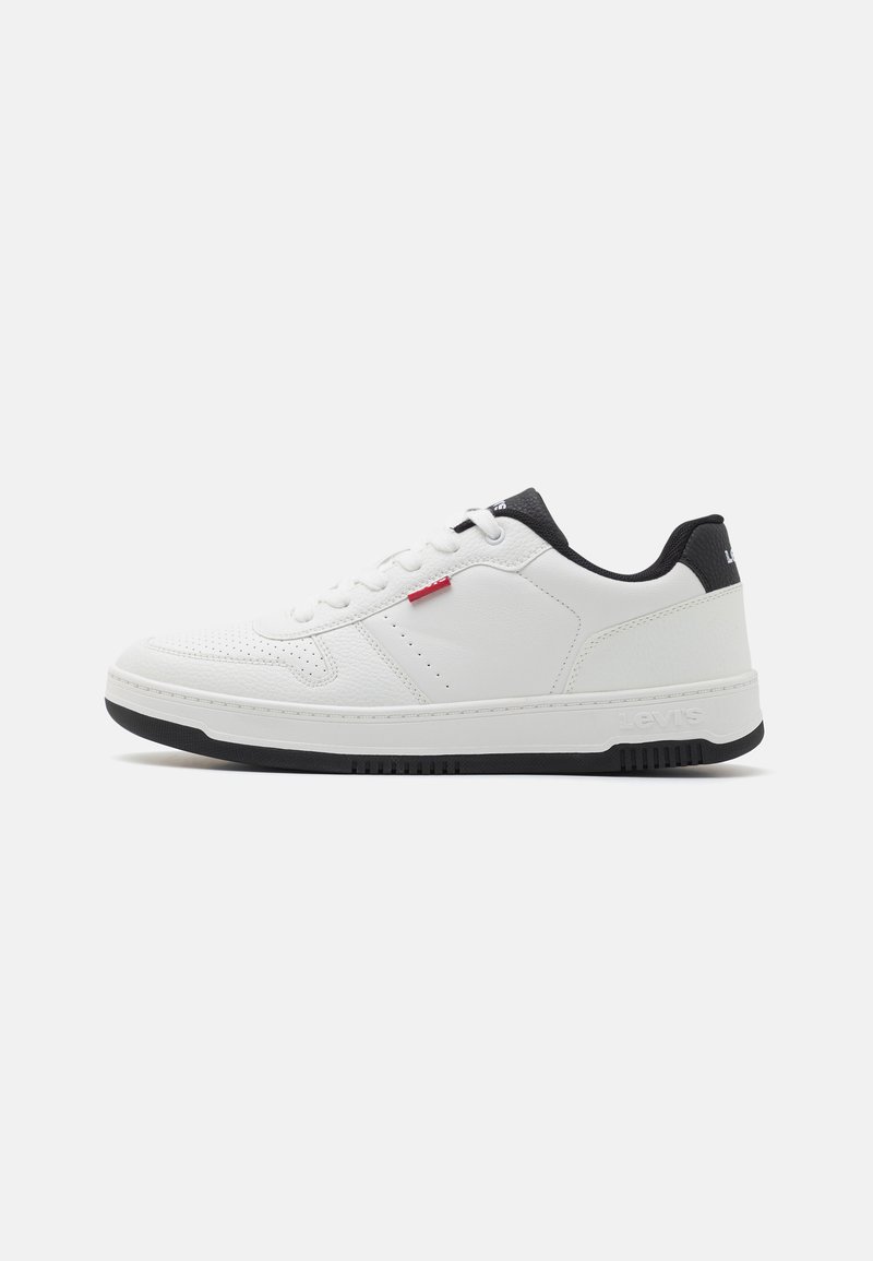 Vit sneaker med en texturerad läderöverdel, svarta accenter vid hälen och en gummisul. Har en snörningsdesign och varumärkeselement.