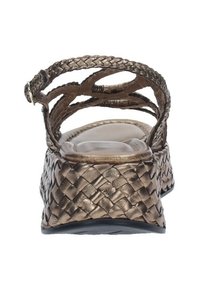 Sandalo wedge in bronzo metallico con design a fascia intrecciata, apertura sul retro e suola testurizzata. Fibbia regolabile alla caviglia per una vestibilità sicura.