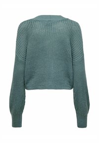 Pletena majica u umjerenoj tirkiznoj boji. Ima okrugli izrez, duge rukave s rebrastim manžetama i skraćeni kroj. Tekstura pletiva.