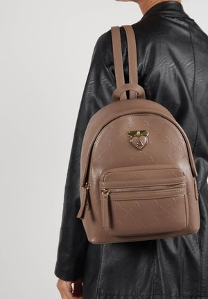 Sac à dos en faux cuir marron avec motif gaufré, présentant des accessoires en or, une poignée sur le dessus et une poche zippée à l'avant. Deux bretelles.