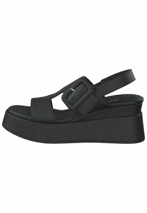 Black platform sandals with a sleek, curved design, featuring a wide buckle strap, open toe, and a textured sole for grip.