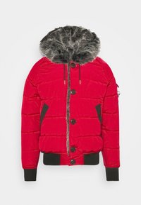 Polstret rød jakke med en grå pelsforet hætte, sorte detaljer på siderne, store frontknapper og elastiske manchetter ved ærmerne og kanten.
