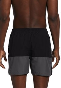 Pantaloni da bagno da uomo neri e grigi con una cintura elastica, tasche laterali e un design a pannelli bicolore. Il tessuto sembra leggero e morbido.