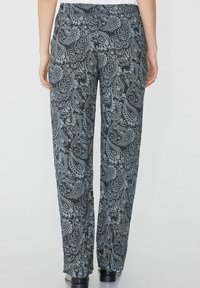 Kalhoty s paisley vzorem v černé a světle modré barvě, uvolněného střihu s elastickým pasem, mají hladkou texturu a rovný střih nohavic.