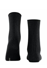 Schwarze gerippte Socken aus weichem Material, mit nahtlosem Design, in mittellanger Länge bis zur Wade und dezentem Logo-Detail an der Ferse.