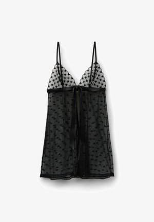 Babydoll de encaje negro transparente con tirantes finos, patrón de corazones, bordes festoneados y una cinta de satén atada en el centro delantero.